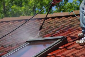 The Safest and Most Effective Method for Roof Moss Removal. House roof cleaning with Soft washing pressure tool. Moss removing with water. Tile washing with professional equipment.