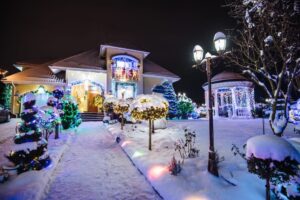 Christmas Light Installation. House Decorated and Lighted for Christmas at Night. Christmas lights outside the house.