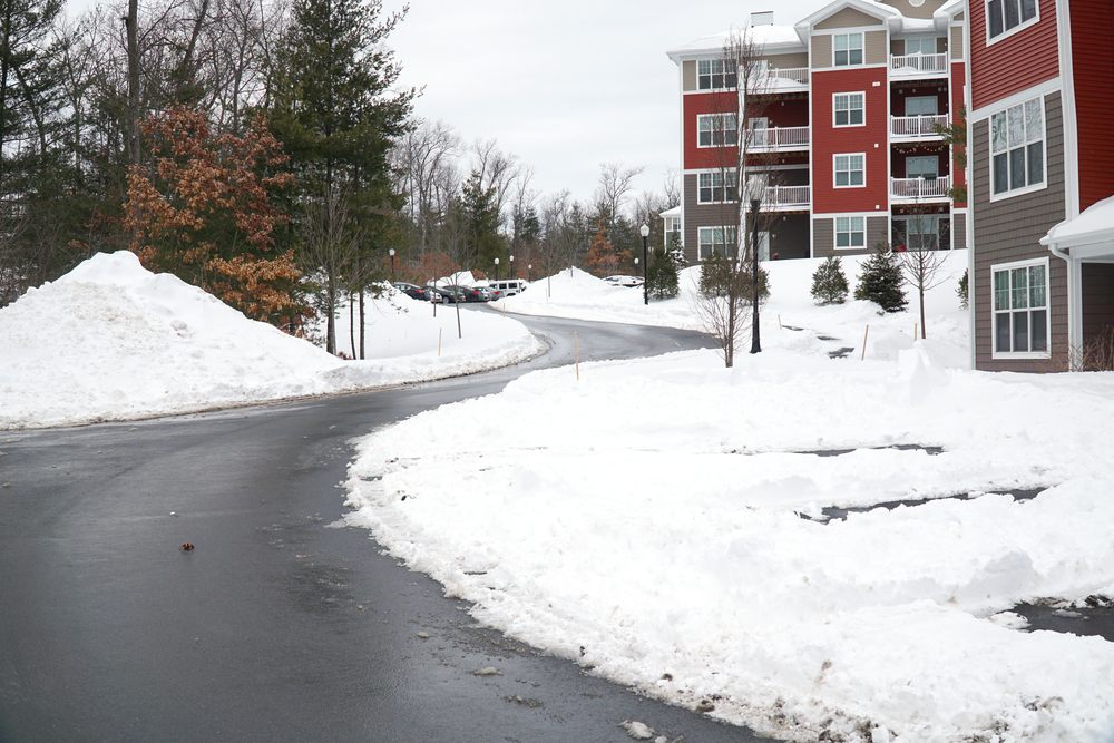 When Should Strata Managers Schedule Snow Removal? modern apartment building after winter snow storm.