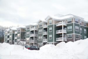 When Should Strata Managers Schedule Snow Removal? modern apartment building after winter snow storm.